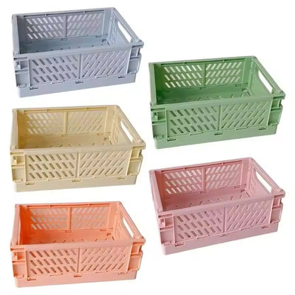 Five collapsible storage crates (10" x 7") in gray, green, yellow, orange, and pink are arranged in two rows against a white background. These multi-purpose crates are perfect for knitting supplies storage and can be easily folded when not in use.