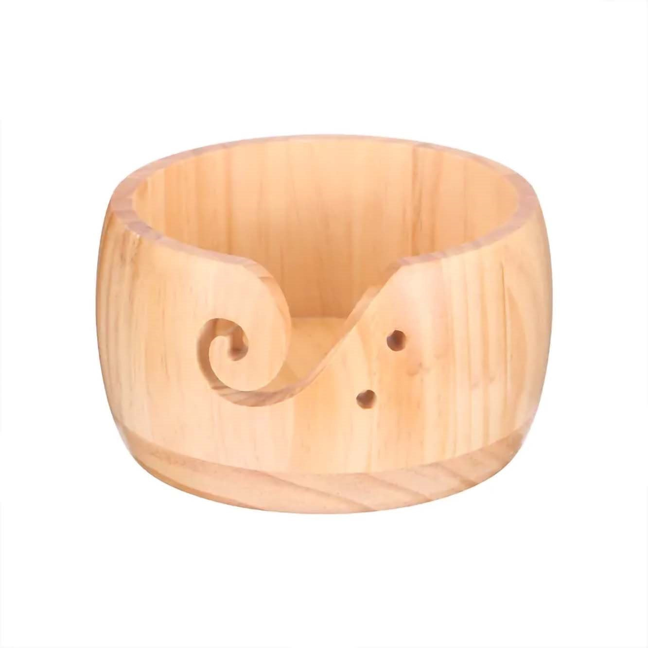 Handcrafted wooden yarn bowl with a curled design and two small holes, isolated on a white background.
