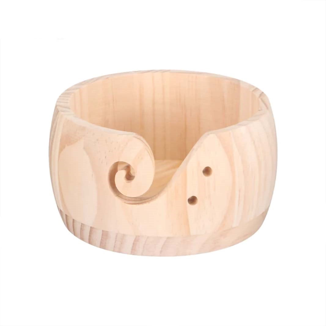 Sentence with product name: A Handmade Wooden Yarn Bowl with a curled slot for guiding yarn and two holes for storing knitting needles, isolated on a white background.