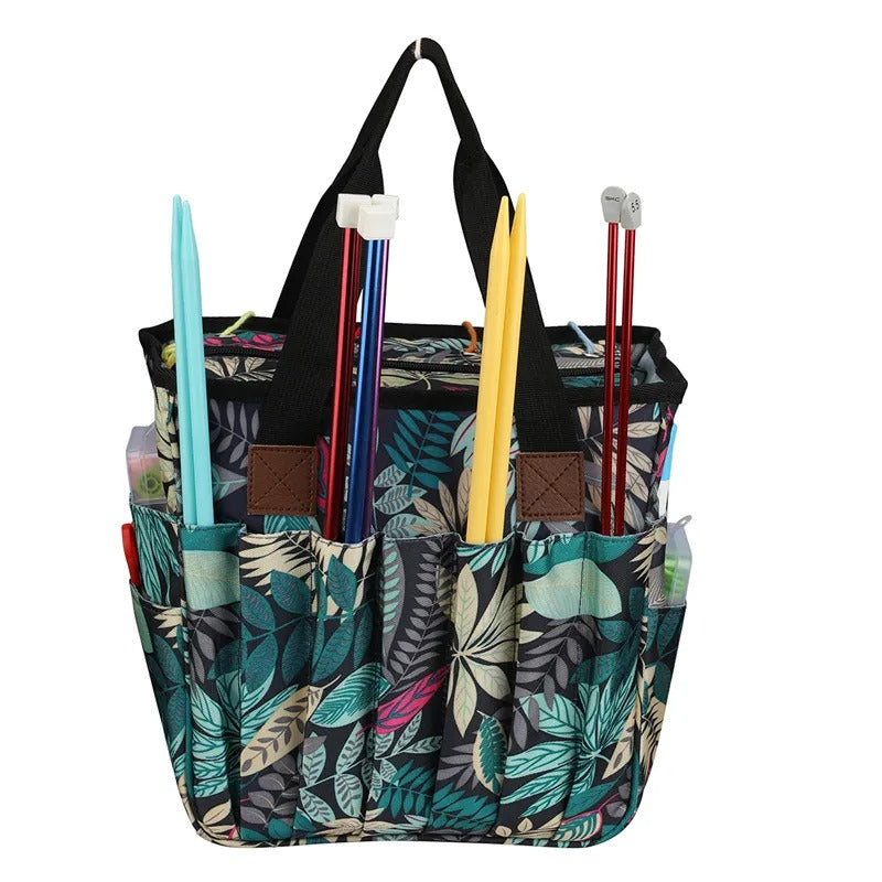 Yarn Organizer Tote featuring a green leaf pattern, expertly designed as the perfect craft organizer, complete with knitting needles and crocheting supplies stored in its exterior pockets.