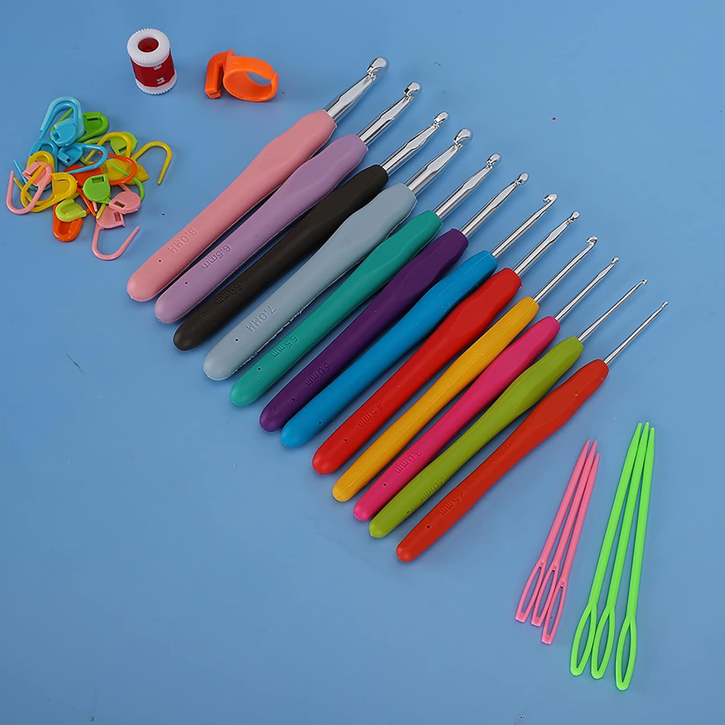 The Crochet Hook Set 31 Pcs with Bag - Beginner Friendly includes colorful hooks, plastic yarn needles, stitch markers, a thimble, and red thread—everything you need for crafting, neatly displayed on a blue surface.