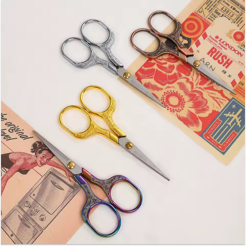 Three ornate pairs of Retro Stainless Steel Yarn Scissors in silver, gold, and multicolored are displayed on vintage floral paper—ideal for precise thread cutting or yarn trimming.