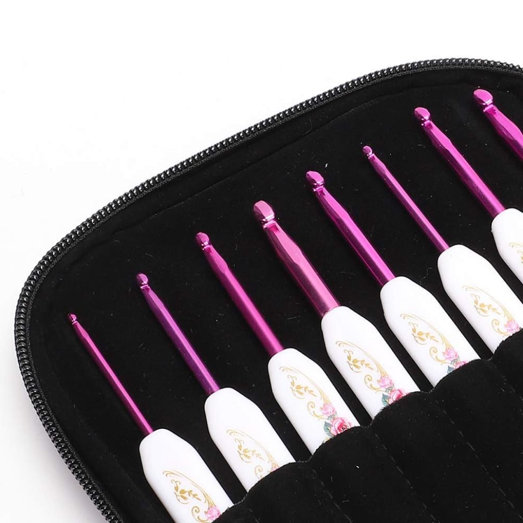 The Crochet Hook Set 16 Pcs with Case includes nine pink artistically designed hooks with white decorative handles, all organized in a black zippered case for easy storage and portability.