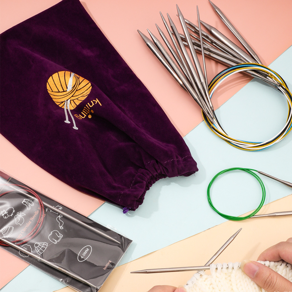 The Stainless Steel Knitting Needle Set, a purple yarn bag, and hands knitting white yarn are displayed on a pastel background, ideal for various knitting projects.