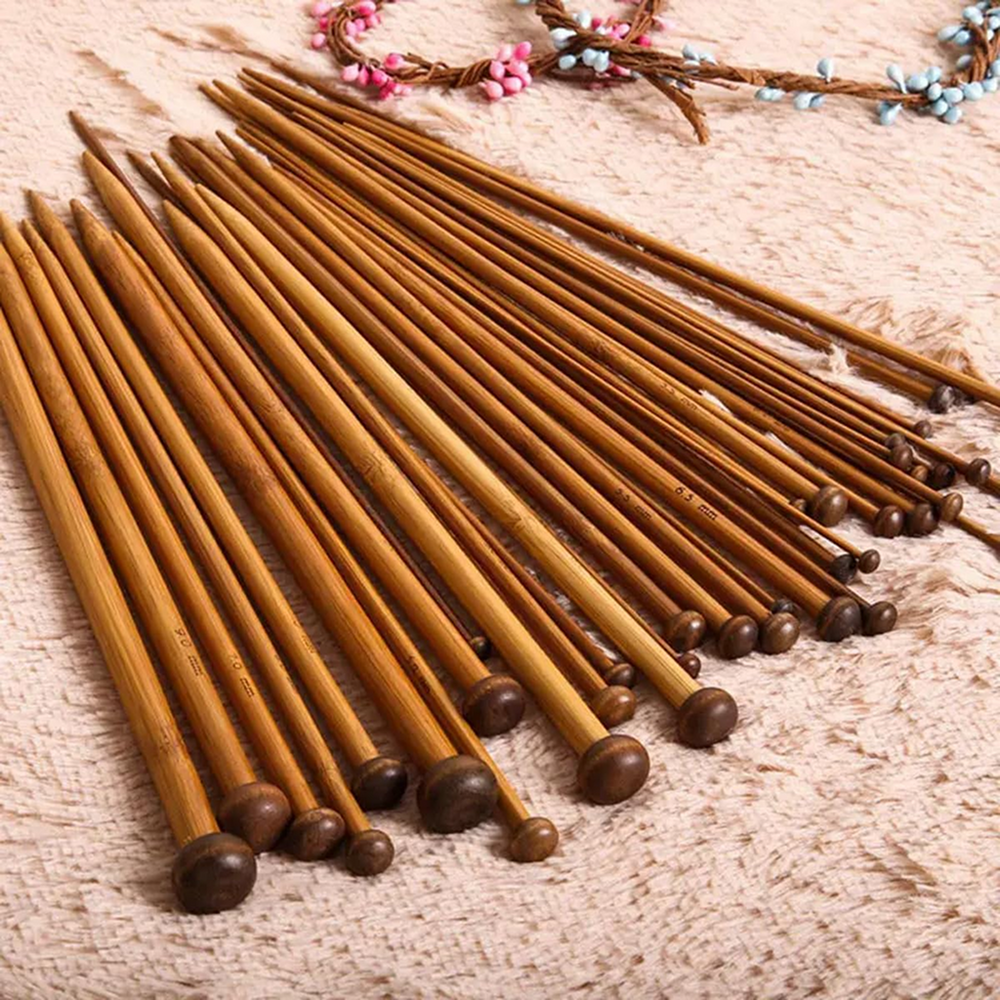 The 36 Pcs Bamboo Knitting Needles set features comfortable, high-quality bamboo needles in assorted sizes, beautifully displayed on a textured beige surface to highlight their quality craftsmanship.