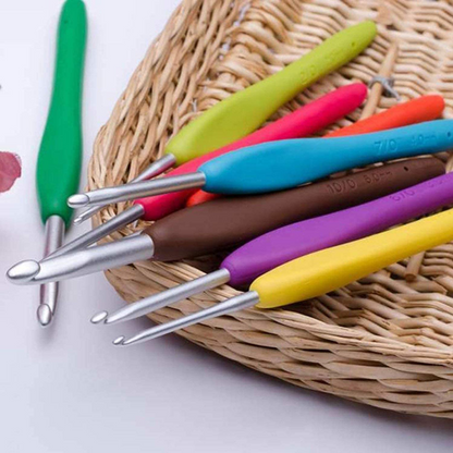 The Ergonomic Crochet Hook Set 9 Pcs features colorful crochet hooks with soft grip handles and durable aluminum tips, arranged beside a woven basket.