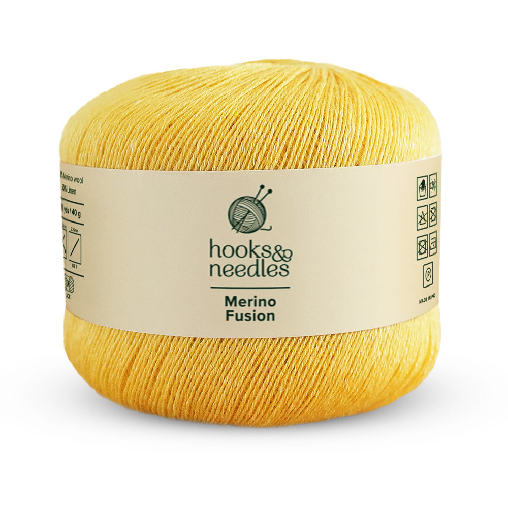 Yellow skein of "Merino Fusion Yarn 40g" lace-weight by "Hooks & Needles" with product label.