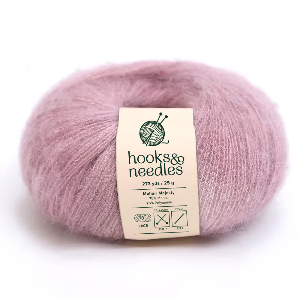 Indulge in the opulence of Mohair Majesty Yarn 25g, featuring a ball of light purple mohair yarn under the "hooks & needles" label. This lace-weight yarn provides 273 yards from a blend of 75% mohair and 25% polyamide, making it an ideal choice for crafting delicate creations.