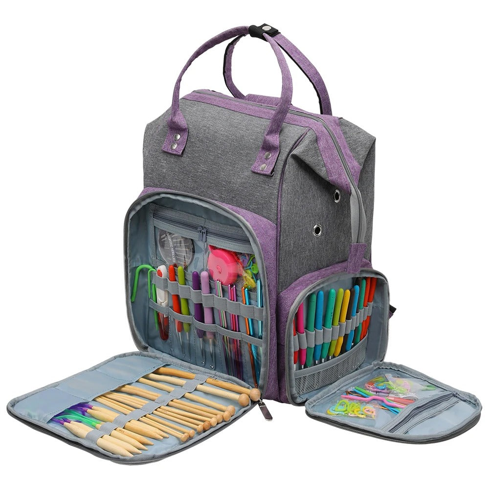 The Oxford Serenity Luxe Bag (bundle) is a durable gray and purple craft bag with handles, made from 600D Oxford fabric. It includes multiple compartments stocked with colorful pens, crochet hooks, and other tools for knitting and crocheting to ensure your supplies are neatly organized.