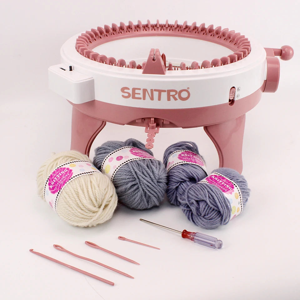 The Bundle48, a 48 Needles Knitting Machine Kit with Row Counter, includes a pink knitting machine and four skeins of yarn in cream, grey, and purple. Along with essential knitting tools and a screwdriver, this set is ideal for both experienced crafters and newcomers to knitting.