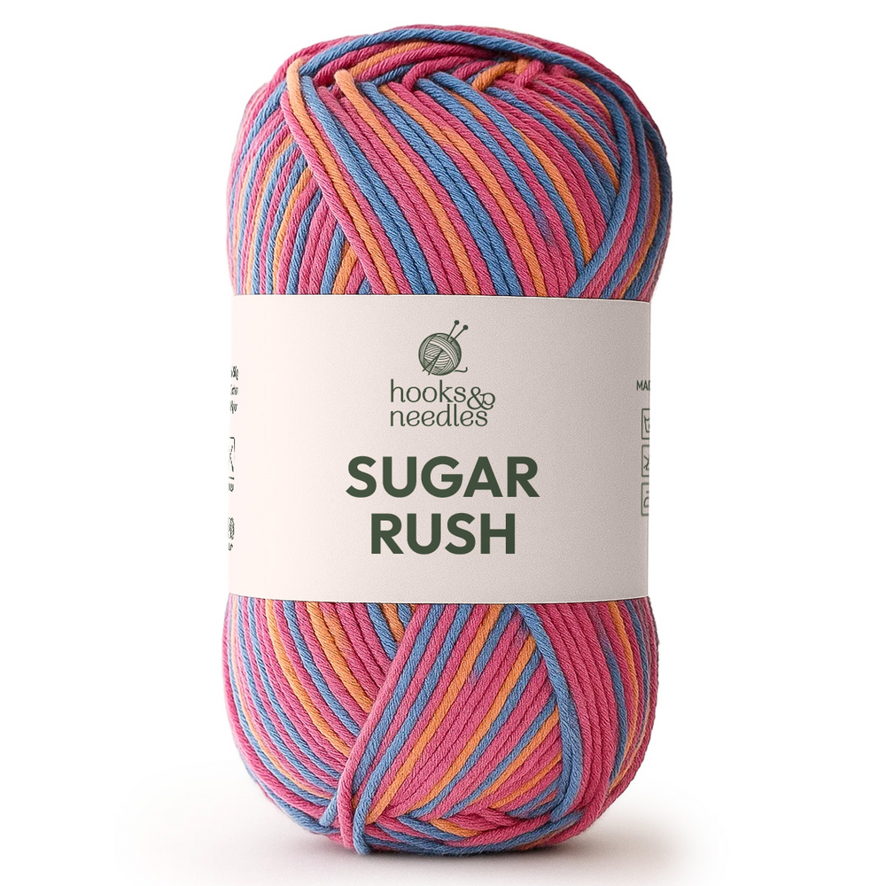 A skein of Sugar Rush Variegated Yarn, a super-fine cotton-acrylic blend by Hooks & Needles, features pink, blue, yellow, and orange strands with a white label.