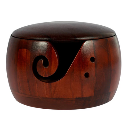 The Wooden Yarn Bowl With Lid features a smooth, polished round design with a carved swirl and two small holes—ideal for keeping your yarn organized during knitting projects.