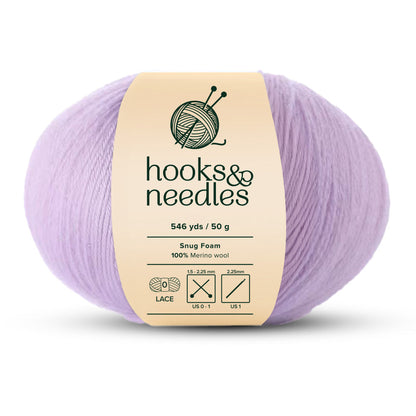 The Snug Foam Yarn 50g in a light lavender lace-weight offers 546 yards and is expertly crafted from merino wool, making it ideal for knitting and crochet projects requiring needle sizes from 1.5-2.25 mm or US sizes 000-1, labeled under "hooks & needles.