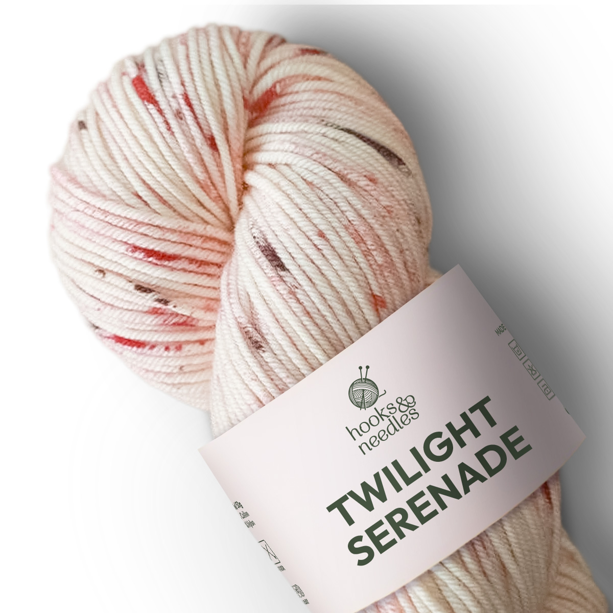 Twilight Serenade Variegated Yarn—a medium weight, cream merino skein with pink and brown speckles from Hook & Needle Co—is perfect for your next cozy project.