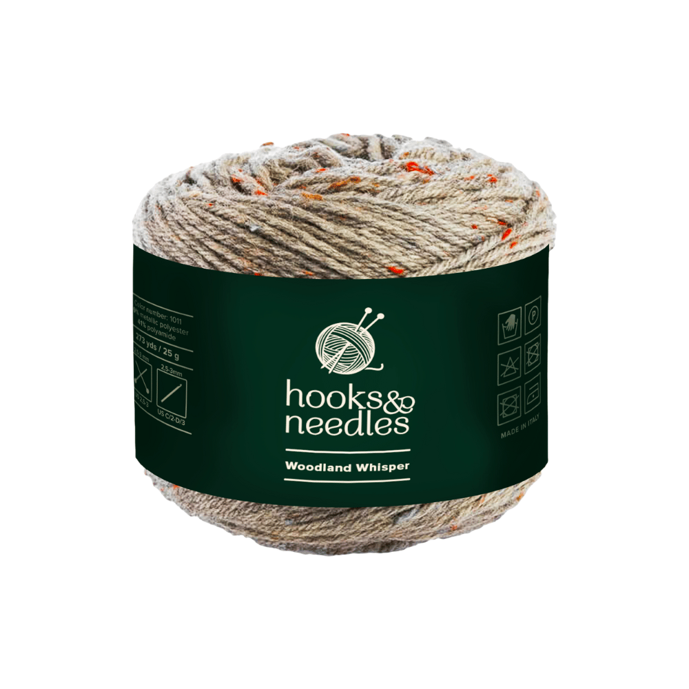 The Woodland Whisper Yarn 50g by Hooks & Needles, crafted from luxurious viscose blend, features a mix of beige and orange fibers.