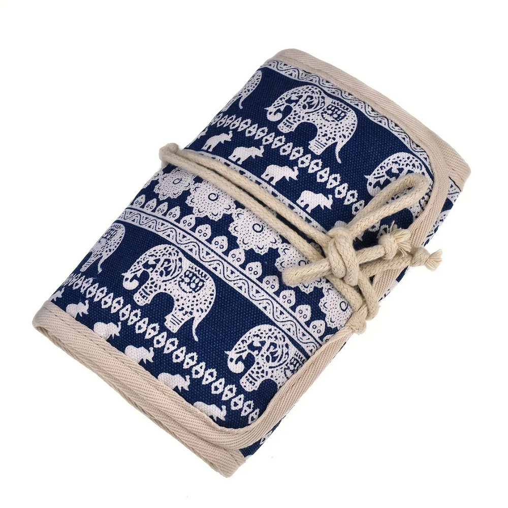 A Crochet Hooks Organizer featuring a stylish blue and white elephant pattern, ideal for streamlined crafting, is rolled up and tied neatly with a beige cord.