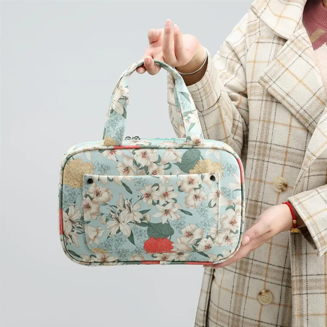 Person holding a Compact Tote Bag with a floral pattern against a neutral background.