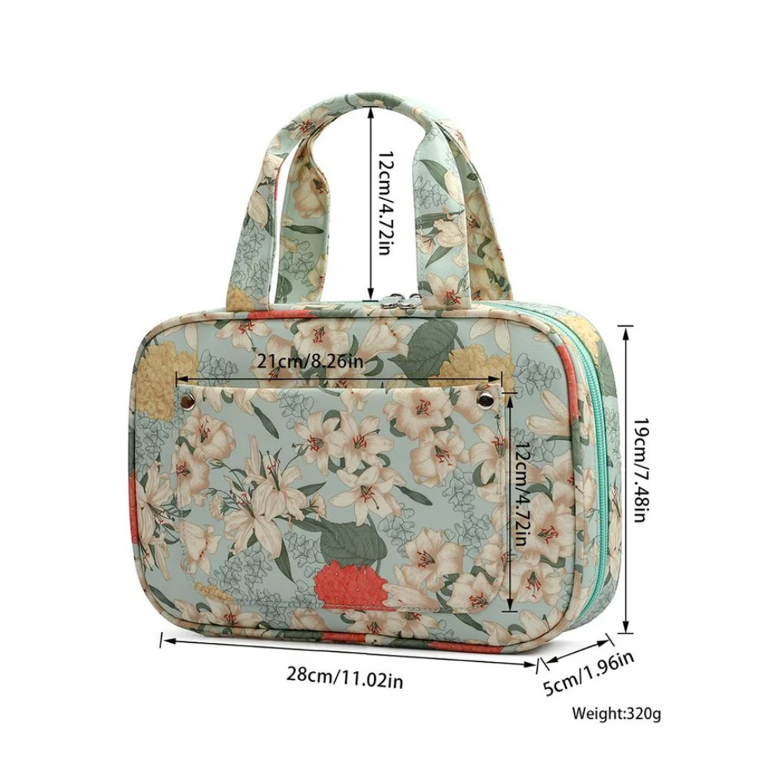 The Compact Tote Bag, adorned with a floral pattern, measures 28cm x 21cm x 5cm and weighs 320g. It features dual handles and a front pocket, making it the ideal crafting companion for your knitting supplies.