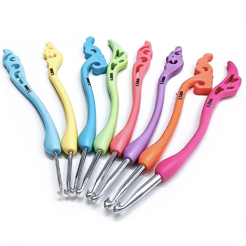 A Vintage-Style Crochet Hook Set 8 Pcs with Soft Handle featuring seven hooks with colorful silicone handles and various ornamental shapes at the ends, laid out in a row.