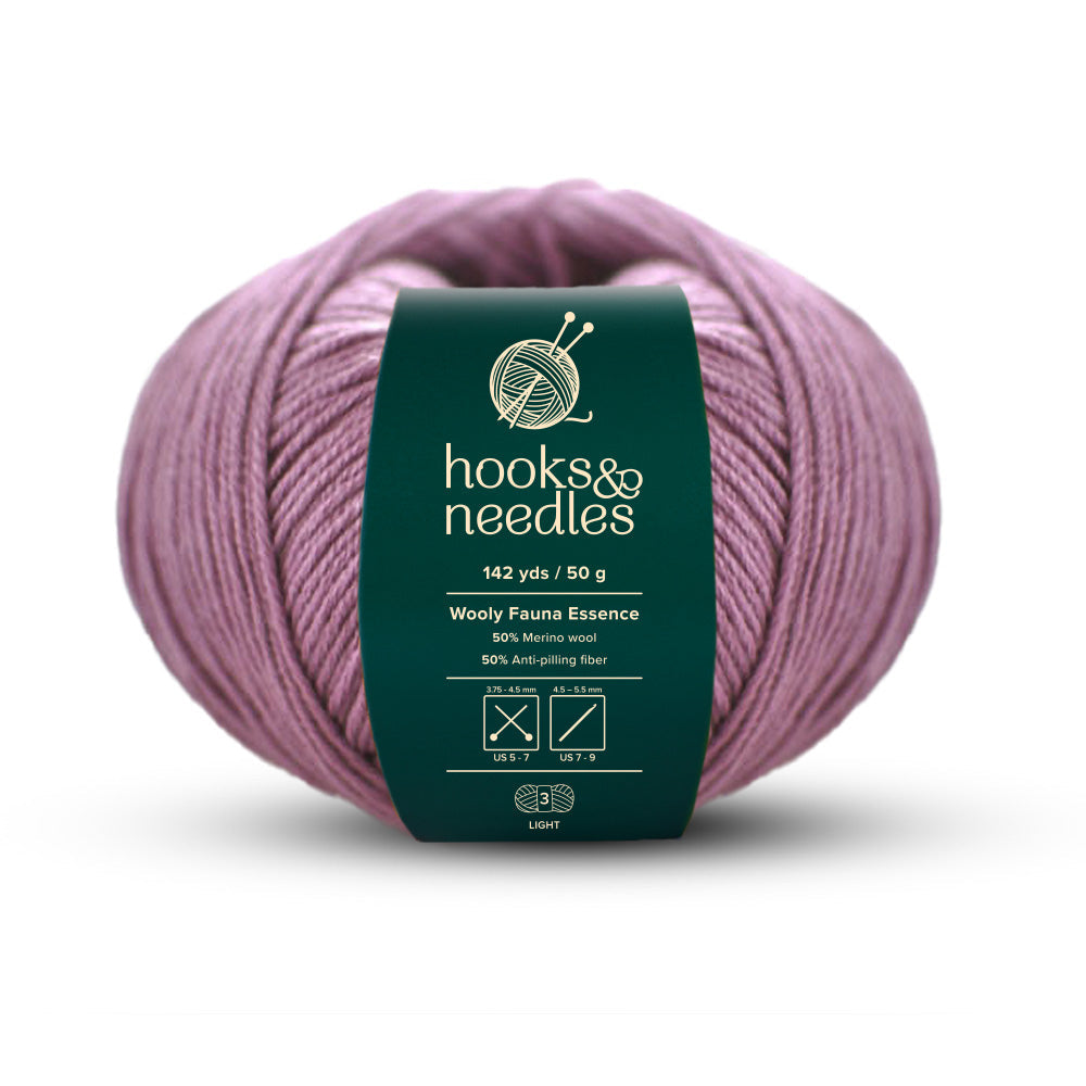 Experience the magic of Wooly Fauna Essence Yarn 50g, featuring a delicate light pink merino wool blend interwoven with 50% anti-pilling fiber. With 142 yards per 50 grams, this lightweight yarn is ideal for crafting your next cozy masterpiece.