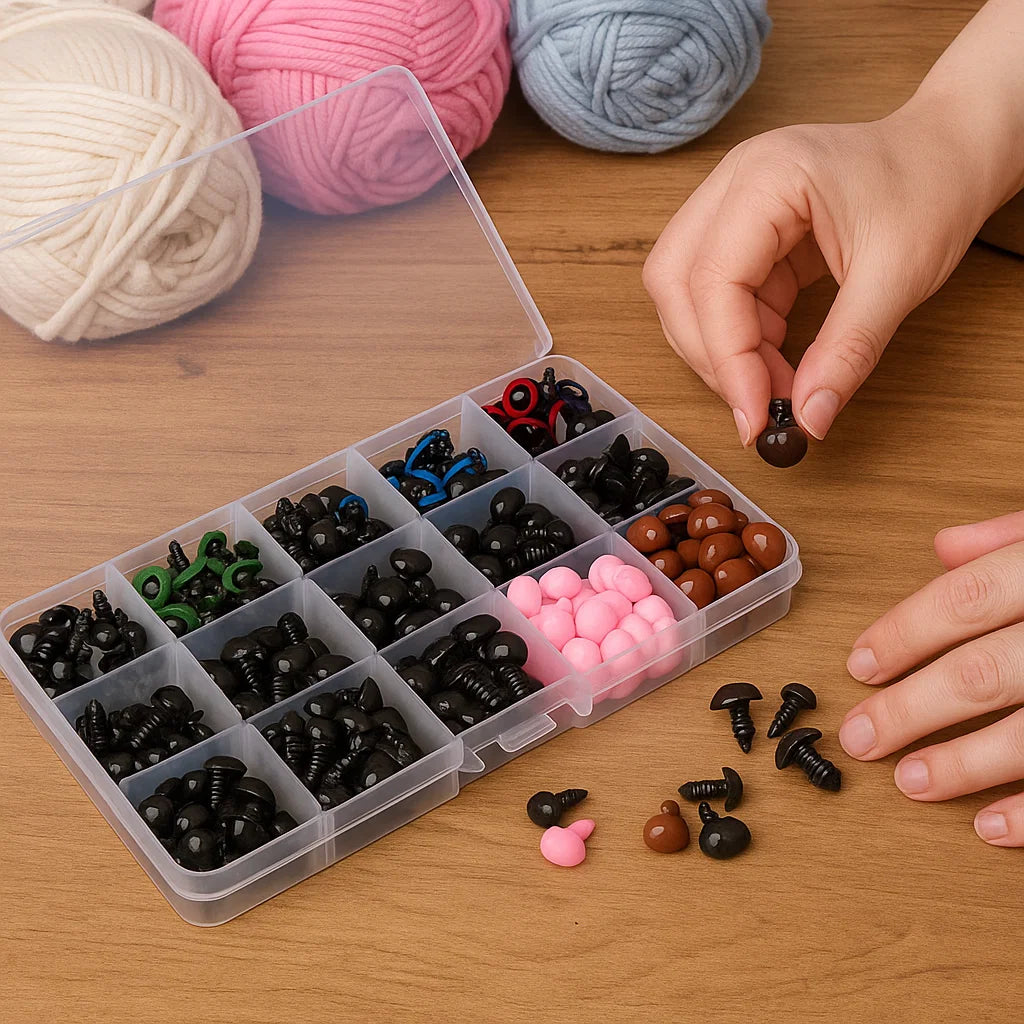 The Crafting Safety Eyes & Noses Set is a plastic organizer with assorted pieces for amigurumi or crochet crafts. A hand picks a black piece, while yarn balls appear in the background on a wooden surface.