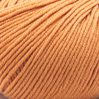 A close-up of Merino Charm Yarn 50g in peach shows the extrafine merino wool skein with neatly wound strands, highlighting its soft fiber texture.