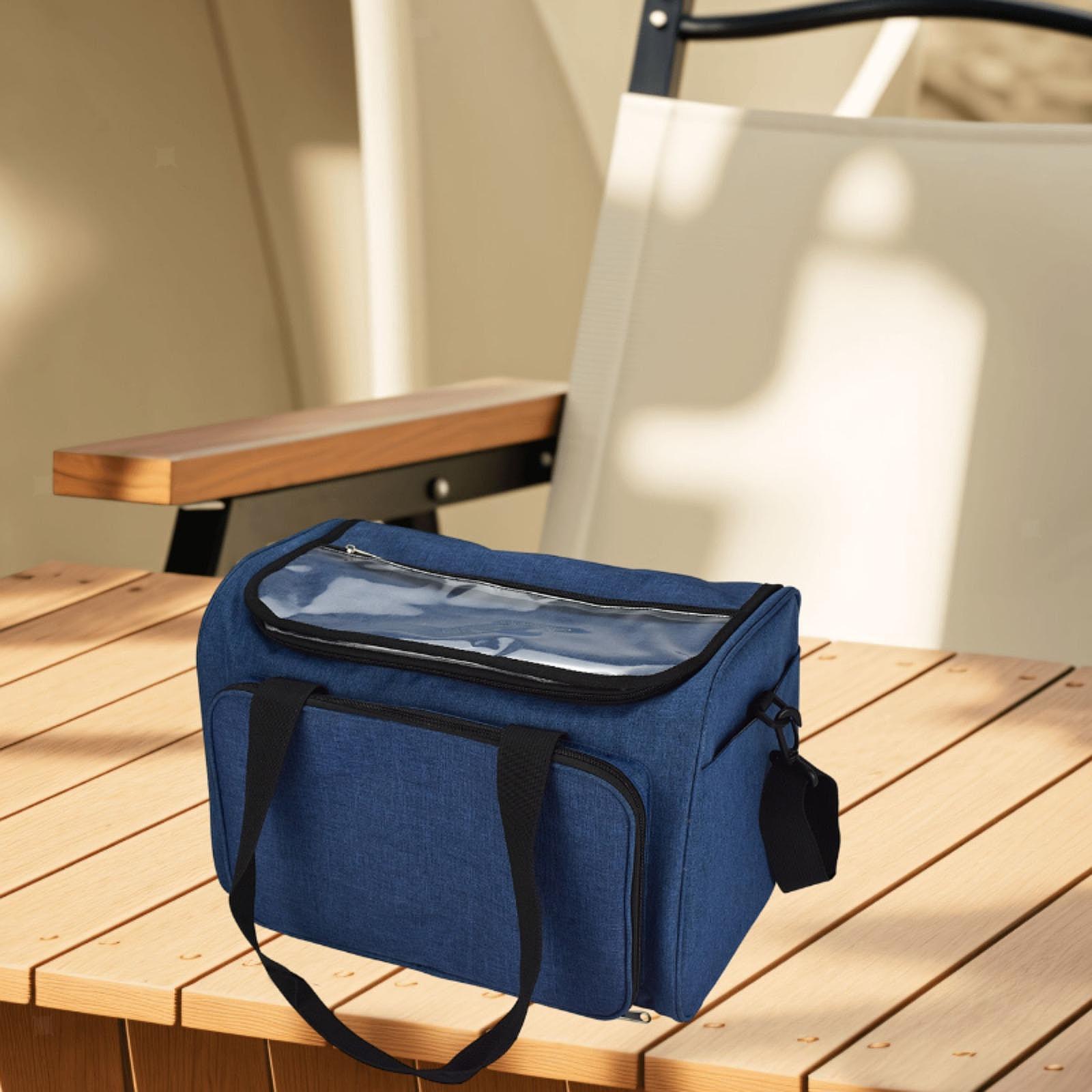 A Large Yarn Organizer Bag with a clear zippered top, ideal for knitting storage, sits on a wooden table beside a beige chair.