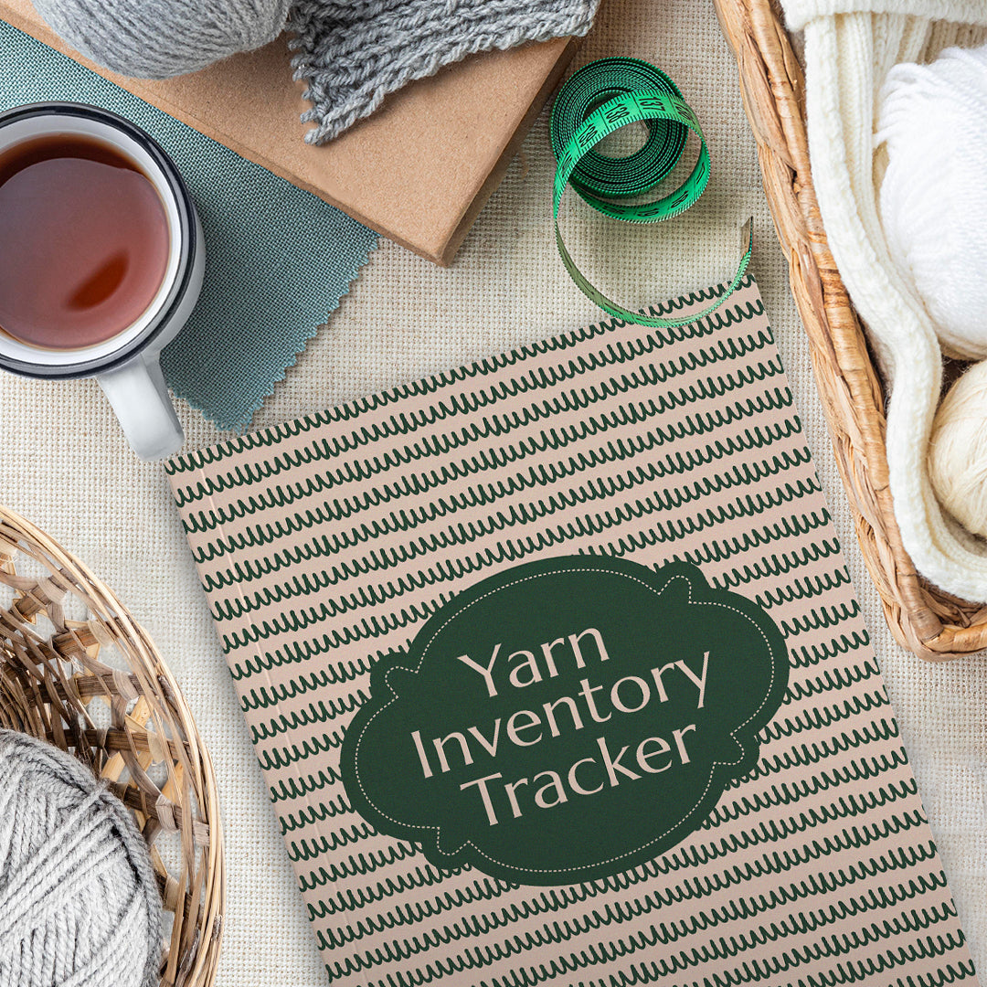 A "Yarn Inventory Tracker" lies on a table surrounded by various yarns, knitting supplies, and a cup of tea.